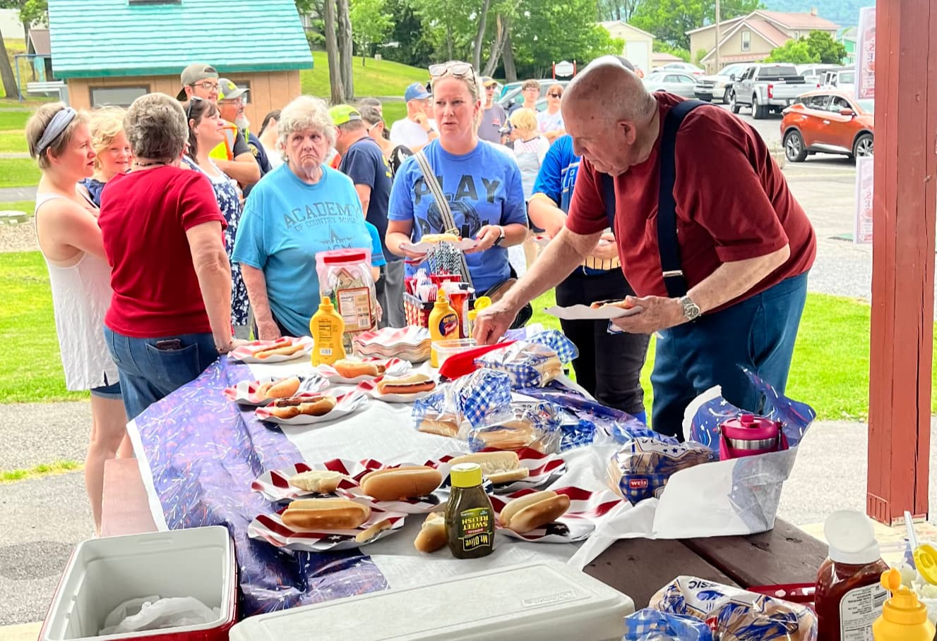 Residents gathered around a small pavilion at Grove Community Park in Flemington, Pennsylvania, sharing food and drinks at the borough's Cheers to 250 Years celebration in June 2026