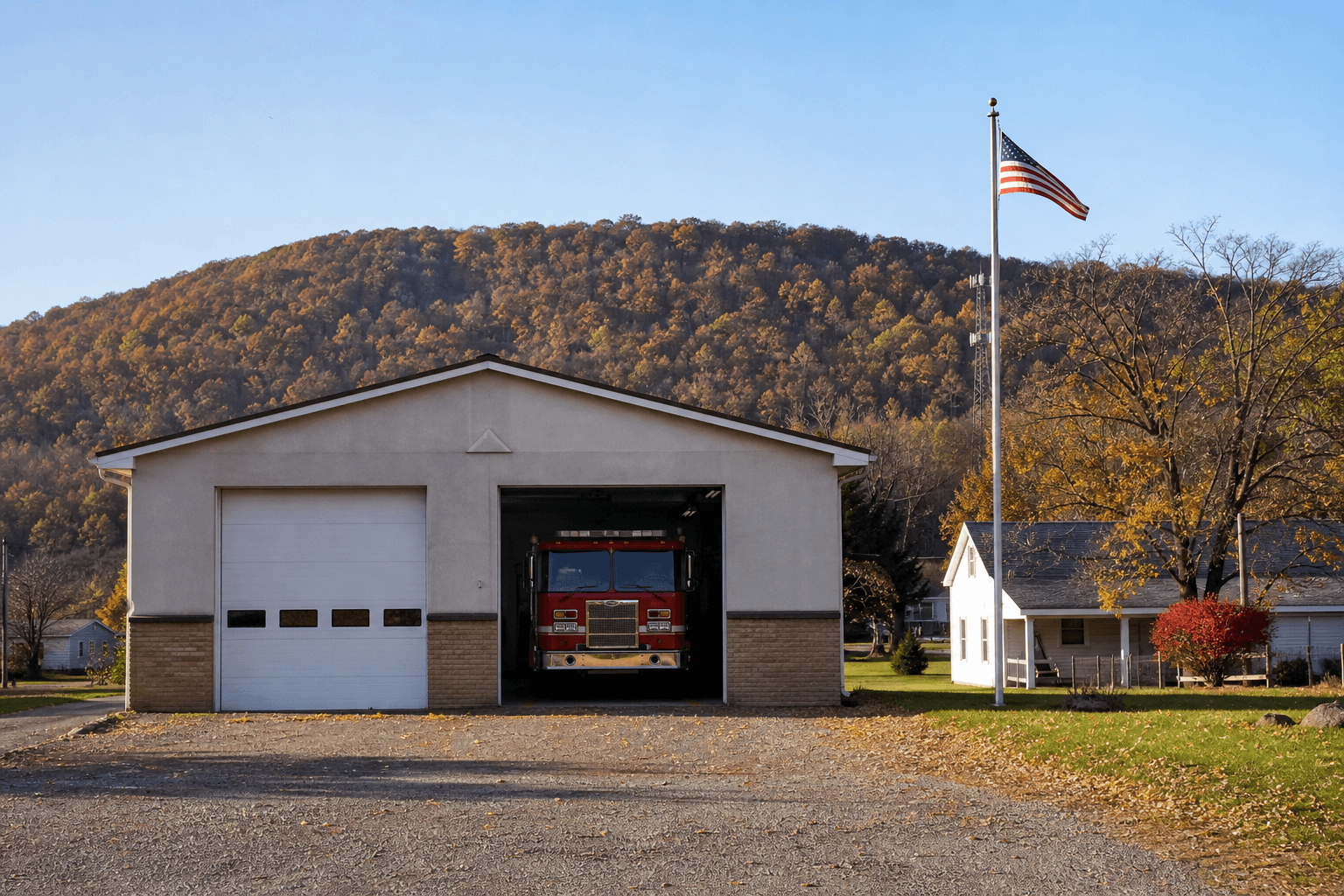 A small rural Pennsylvania volunteer fire station on an autumn afternoon, a red fire engine parked in an open bay