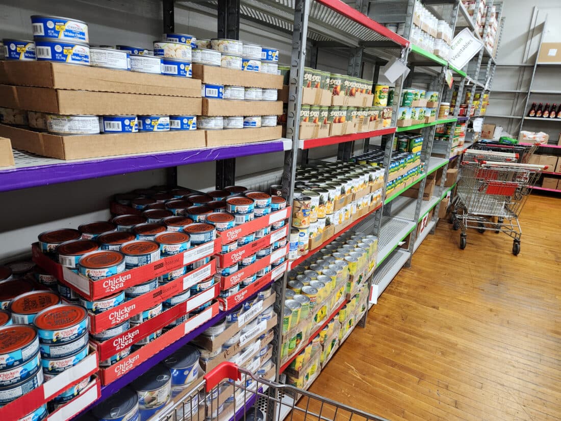 Shelves stocked with canned goods and grocery carts inside the New Love Center's pantry, which is set up like a small grocery store