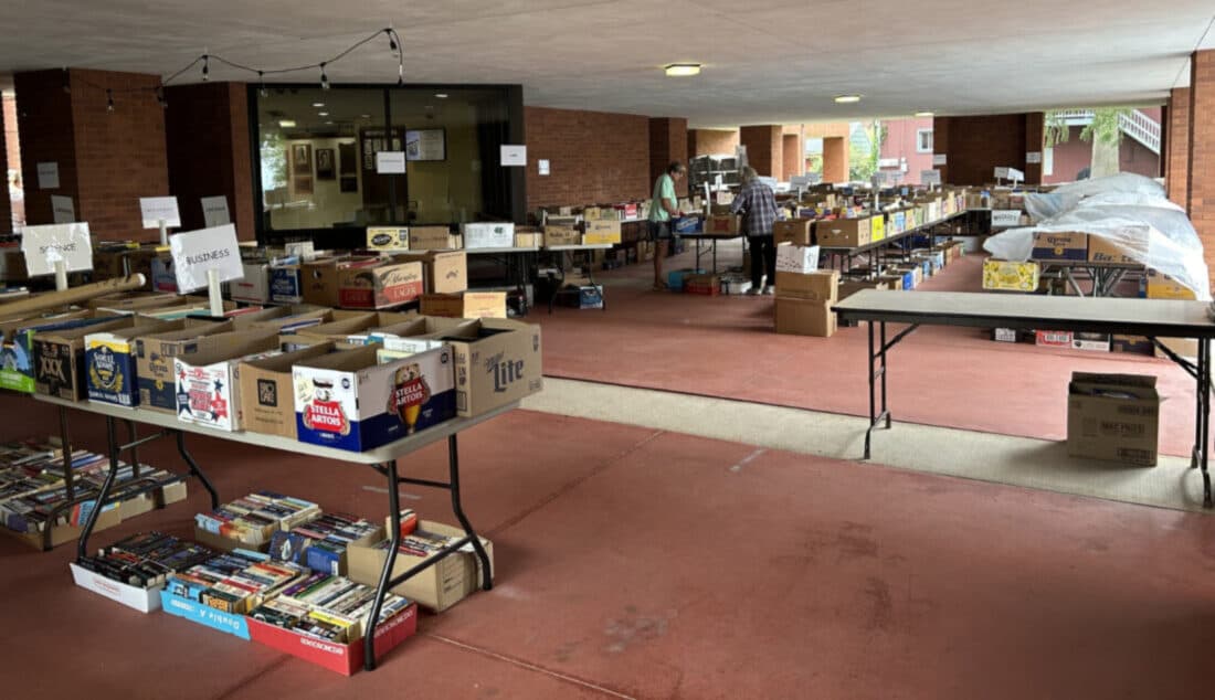 Boxes of donated books sorted by genre on the Annie Halenbake Ross Library patio ahead of the spring book sale in Lock Haven, Pennsylvania