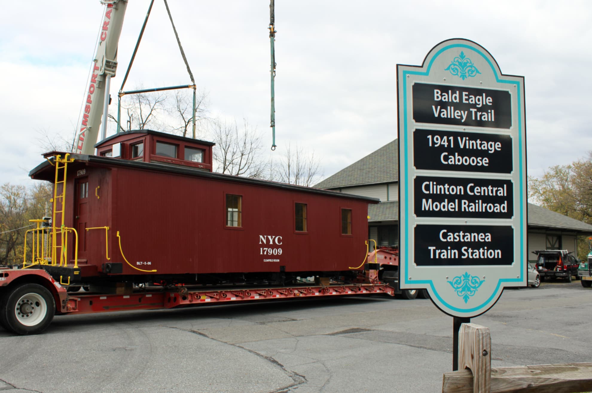 A restored wooden caboose parked on the track in front of the 1883 Castanea Railroad Station in Clinton County, Pennsylvania