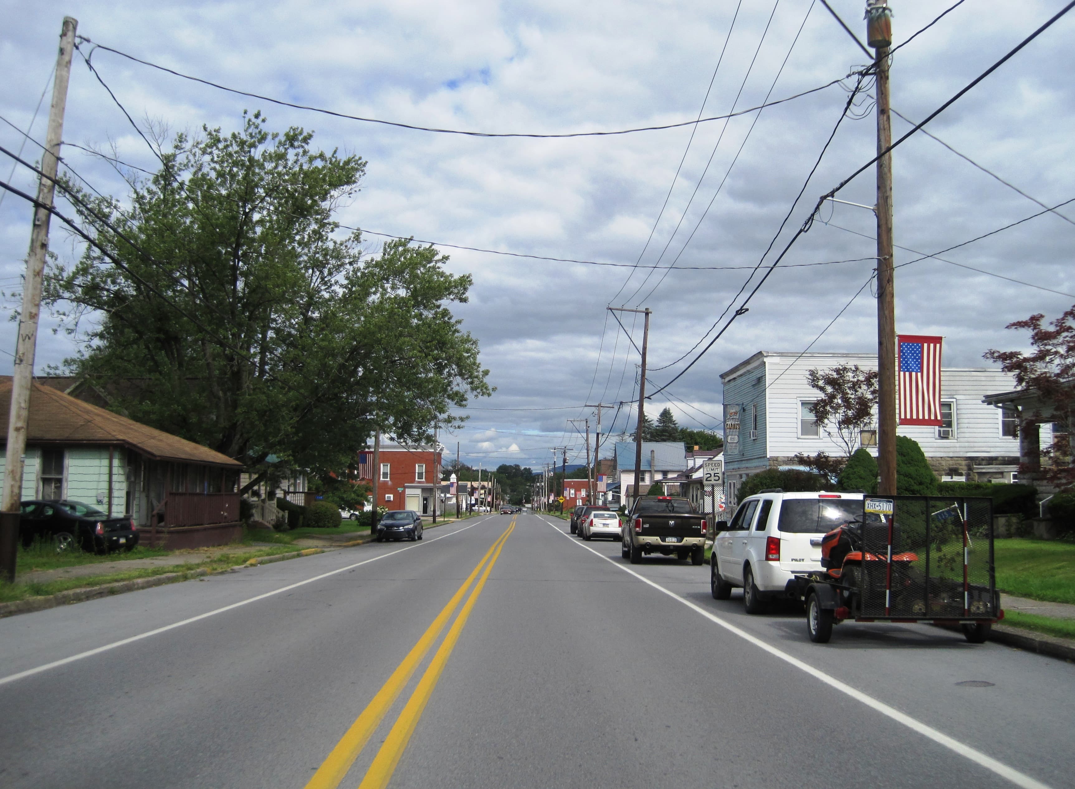 Houses and trees along West Central Avenue in Avis, Pennsylvania, on a clear summer day