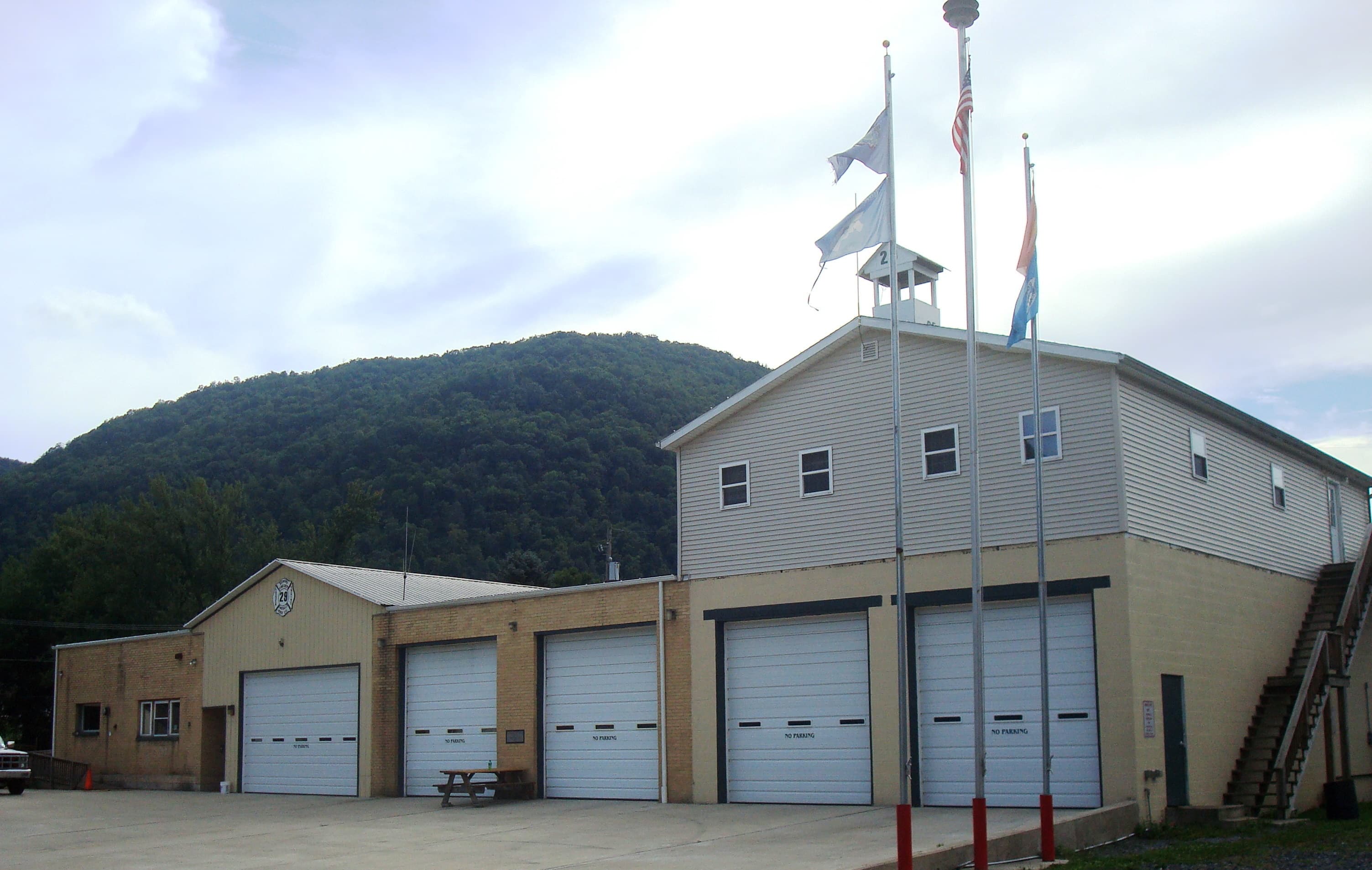 The brick firehouse of the Renovo Fire Department in Renovo, Pennsylvania, with vehicle bay doors facing the street