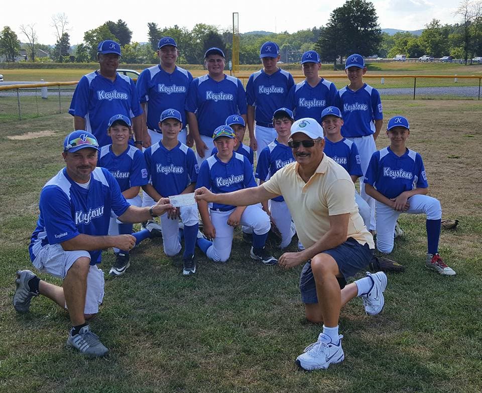 Youth baseball team from Lock Haven, Pennsylvania standing together with the town mayor at a check presentation